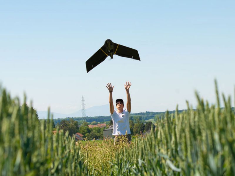 eBee X operator hand launching drone in field