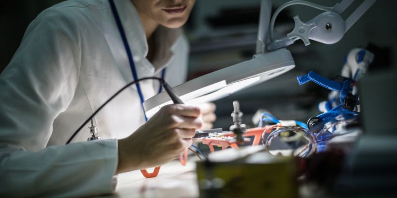 Scientist building machine in lab